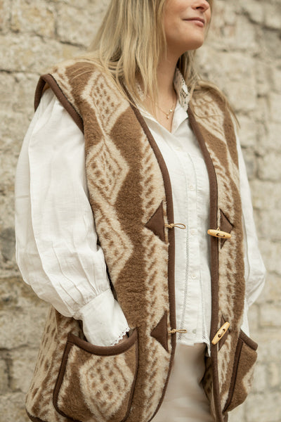 Volwassen vrouw draagt bruine wollen bodywarmer met patroon van Alwerollen bodywarmer met patroon