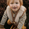 Kind draagt beige wollen bodywarmer van het merk Alwero